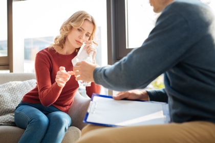 Cheerless Unhappy Young Woman Using A Paper Tissue And Taking A Glass Of Water